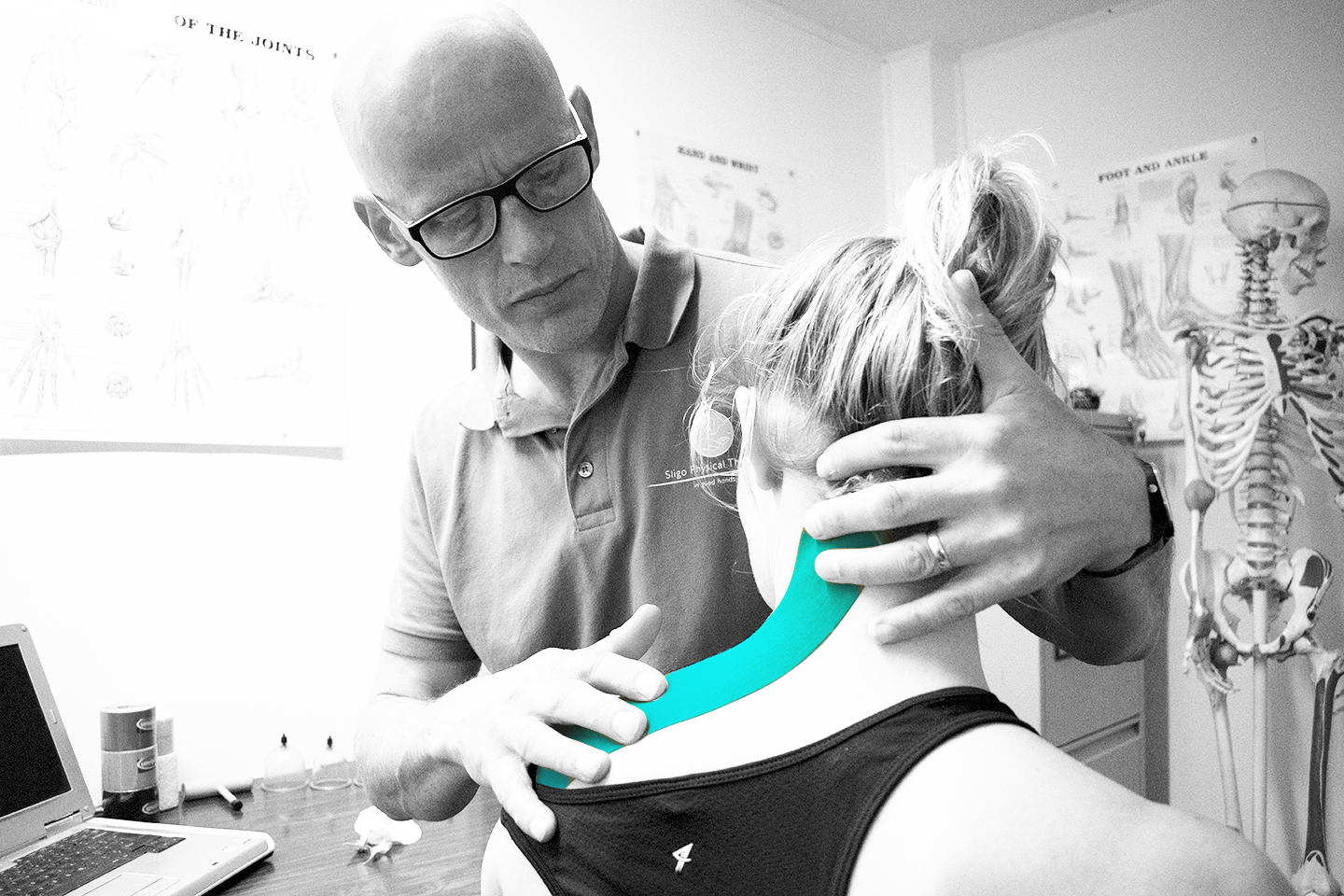 Physio Troy applying kinesio tape to clients neck.